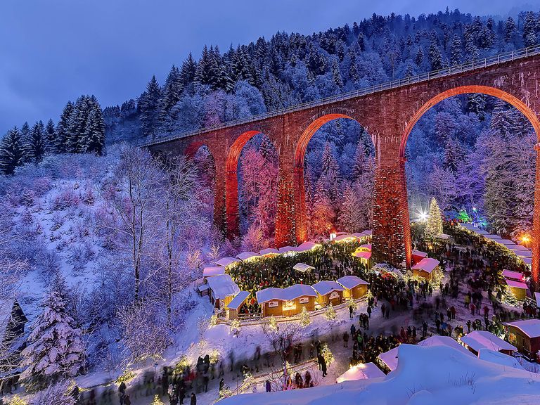 Blick auf die verschneite Ravennaschlucht mit Eisenbahnbrücke und Weihnachtsmarkt