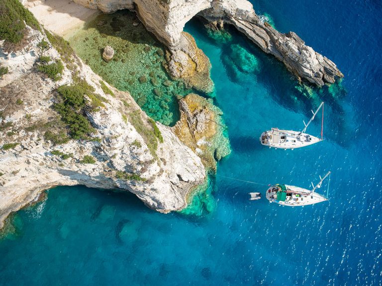 Die Insel Paxos ist noch recht unbekannt. Luftaufnahme einer Bucht mit Booten auf Paxos, Griechenland