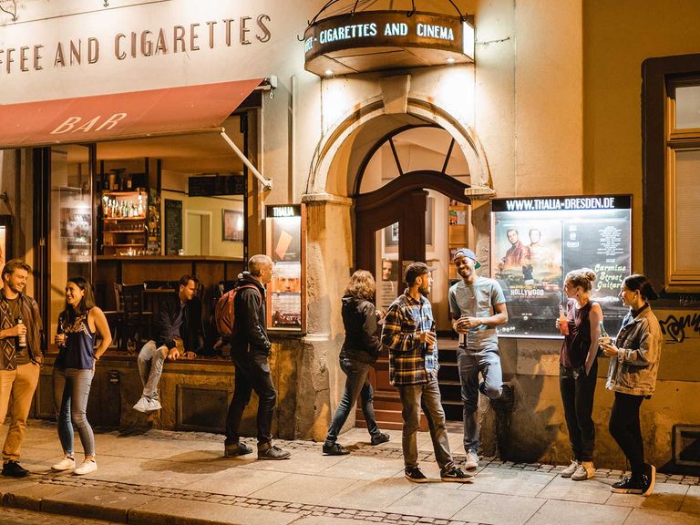 Auf einen Drink oder einen Film: Das kleine Programmkino Thalia an der Görlitzer Straße hat in der Neustadt eine große Strahlkraft. Menschen stehen vor dem Programmkino Thalia an der Görlitzer Straße, Dresden