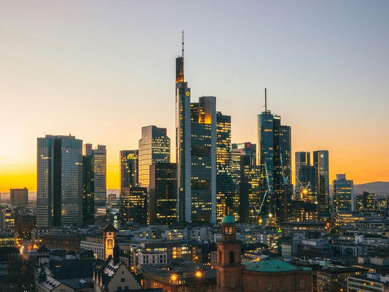 beleuchtete Skyline von Frankfurt am Main beim Sonnenuntergang