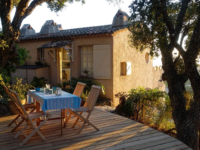 Südfrankreich ist eines der beliebtesten Reiseziele für Landurlaub in Europa. Tische und Stühle vor einem Landhaus in Südfrankreich