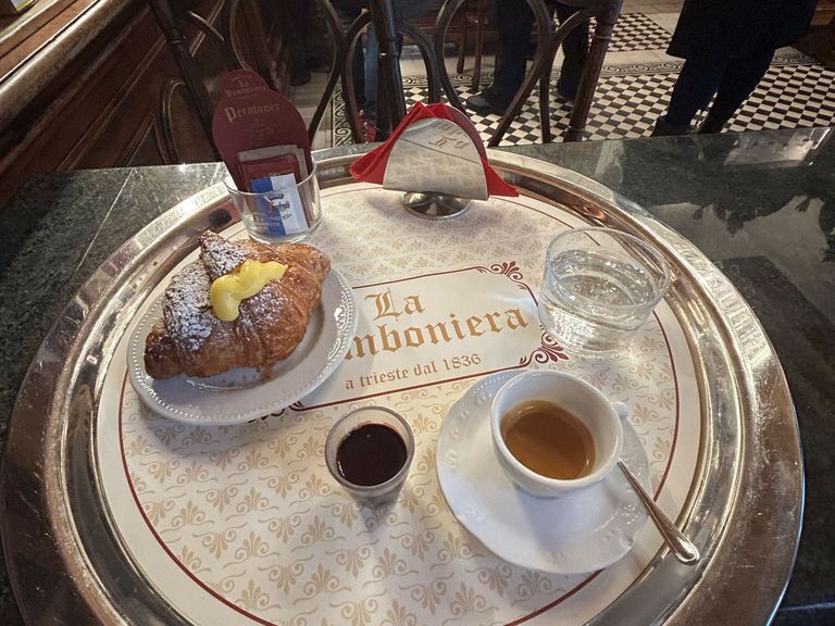 Croissant mit Vanillepudding-Füllung und Espresso in der Pasticceria La Bomboniera