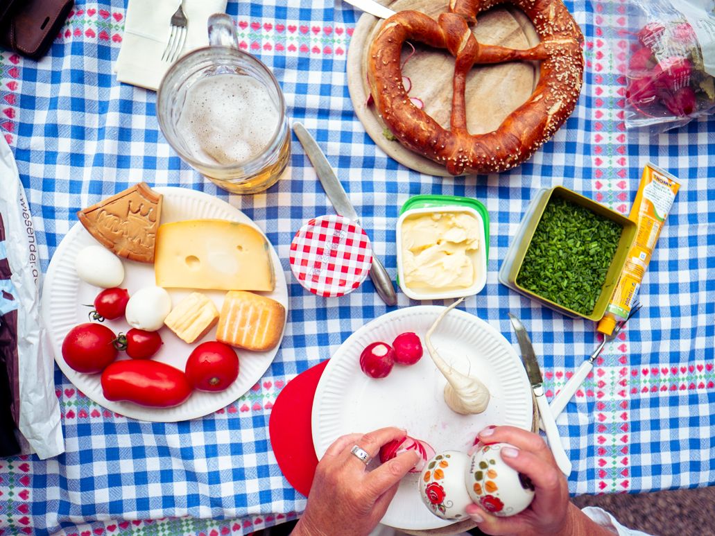 Brotzeit im Biergarten: Brezn und Snacks liegen auf einem Biertisch