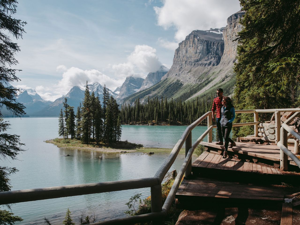 Besucher blicken von einem Steg aus auf Spirit Island, Maligne Lake (Jasper-Nationalpark)