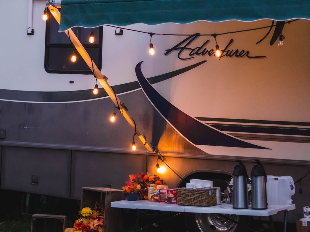Campingtisch neben einem Wohnmobil mit Lichterketten
