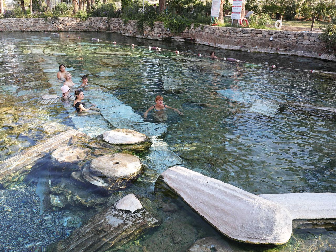 Badegäste schwimmen zwischen antiken Säulen im Kleopatra Pool