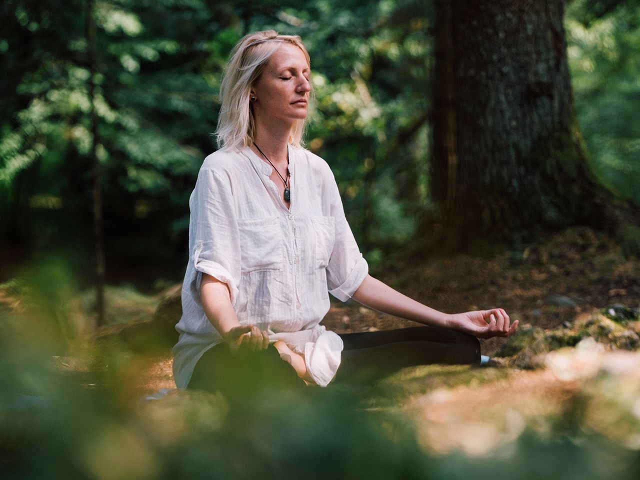 Frau meditiert im Wald