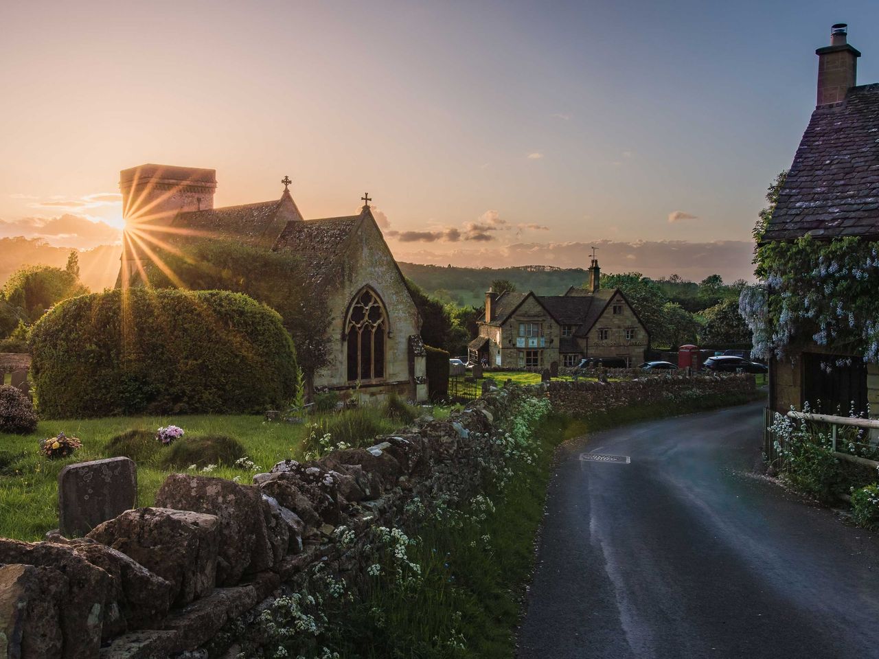 Die Sonne geht hinter der St Barnabas Church in Snowshill (Cotswolds) unter