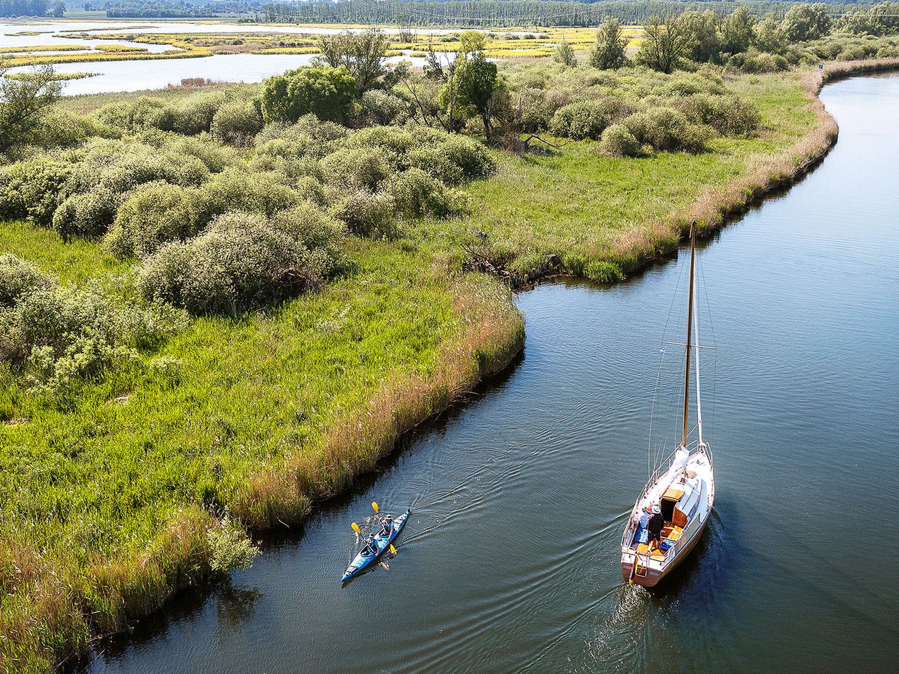 kleines Schiff und Paddelnde auf der Peene
