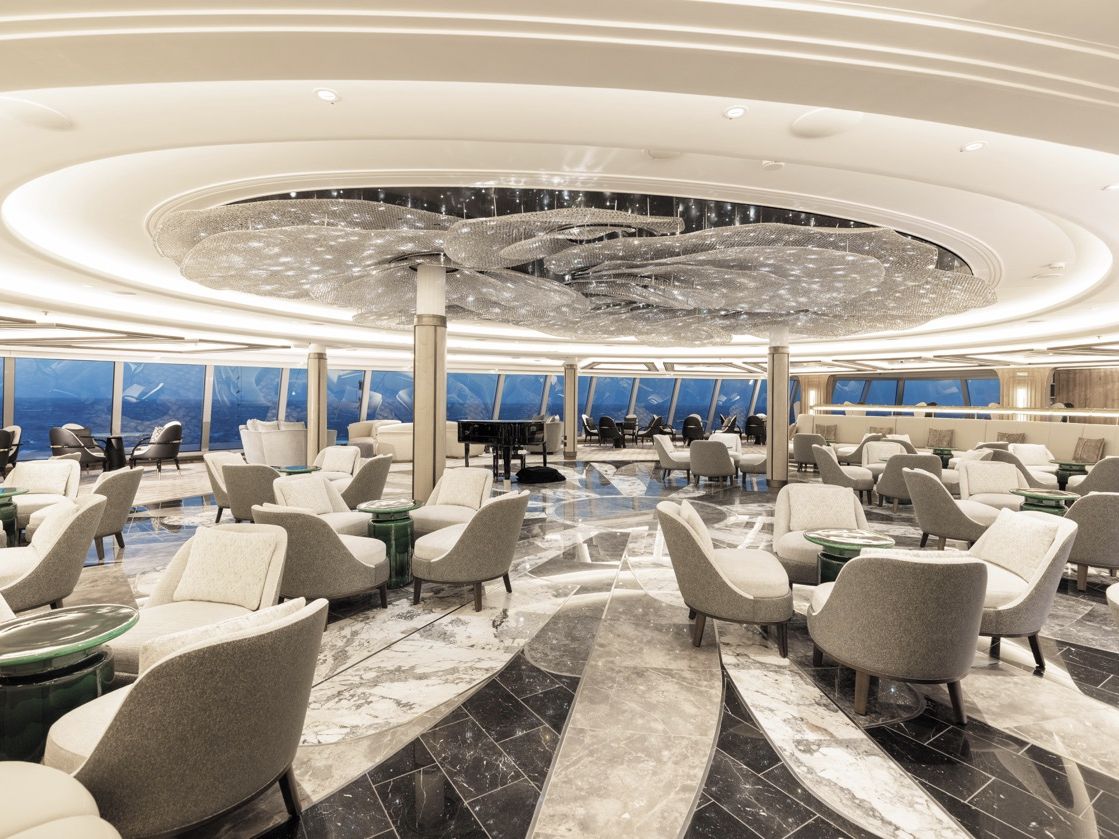 Eine weitl&auml;ufige, elegant gestaltete Lounge mit Sesseln, Panoramafenstern und dekorativer Deckeninstallation.