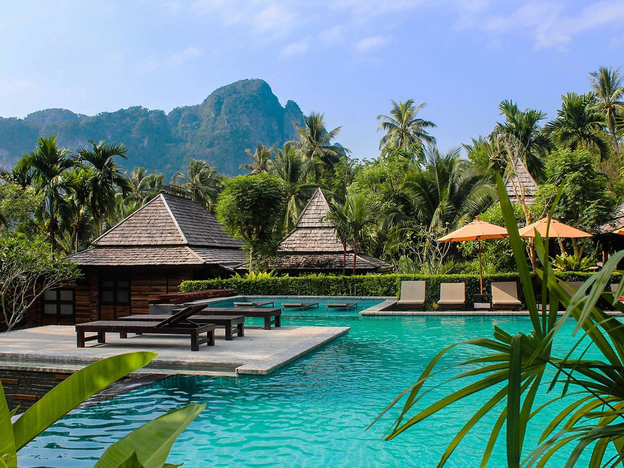 Bungalows stehen am türkisfarbenen Wasser in Thailand