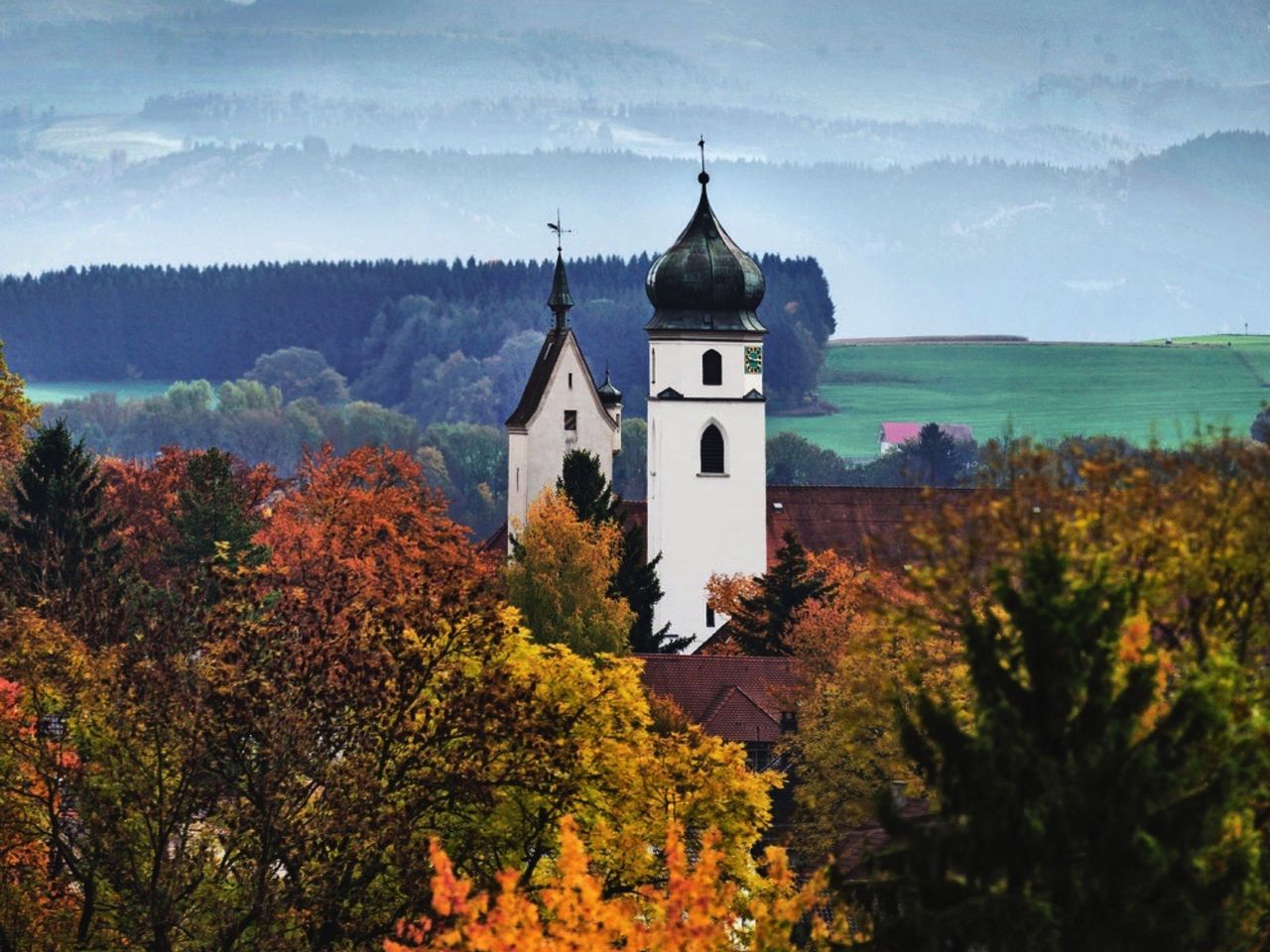 Die Kirche St. Martin in Leutkirch erhebt sich vor dem Alpenpanorama