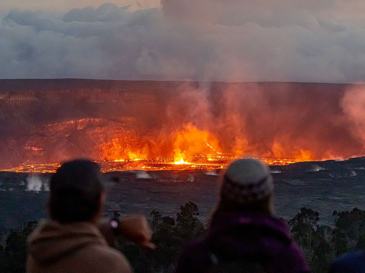 Besucher:innen stehen am Rand des Lavasees am Kilauea auf Big Island.
