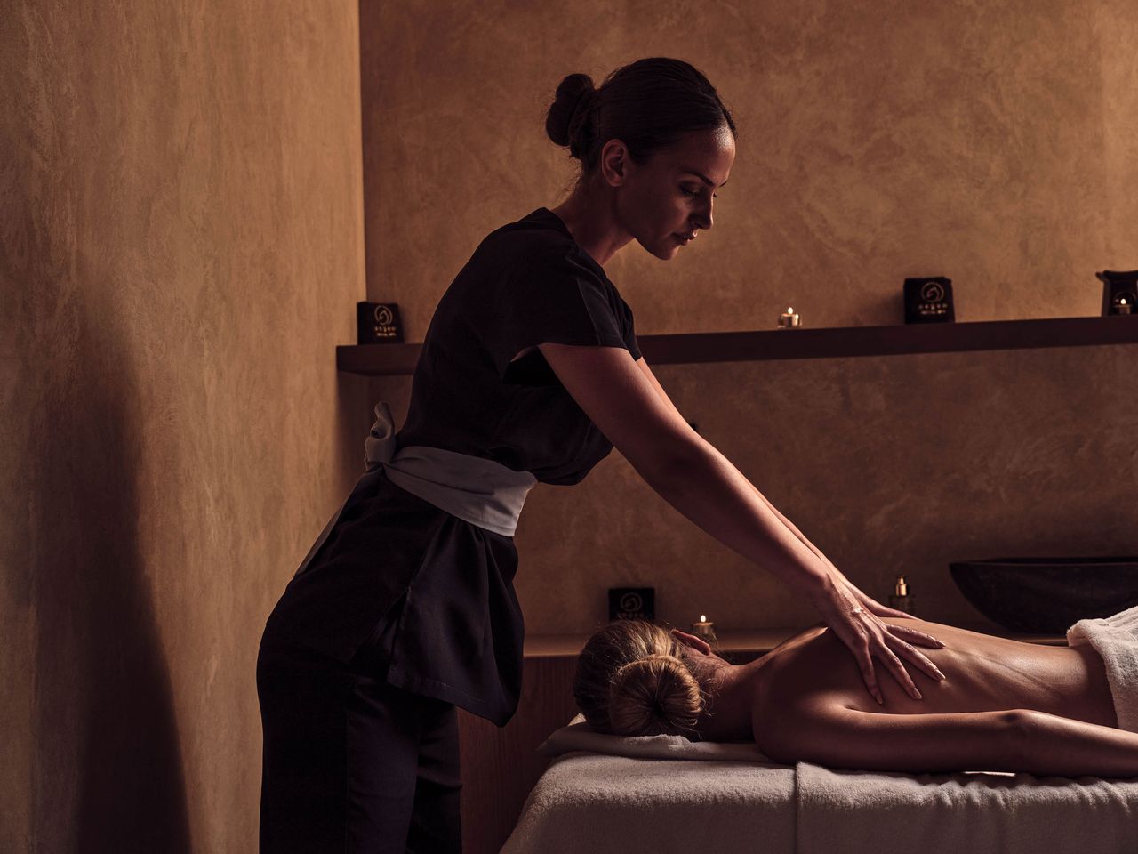 Masseurin bei einer Anwedung an einer Gästin, Olea All Suite Hotel