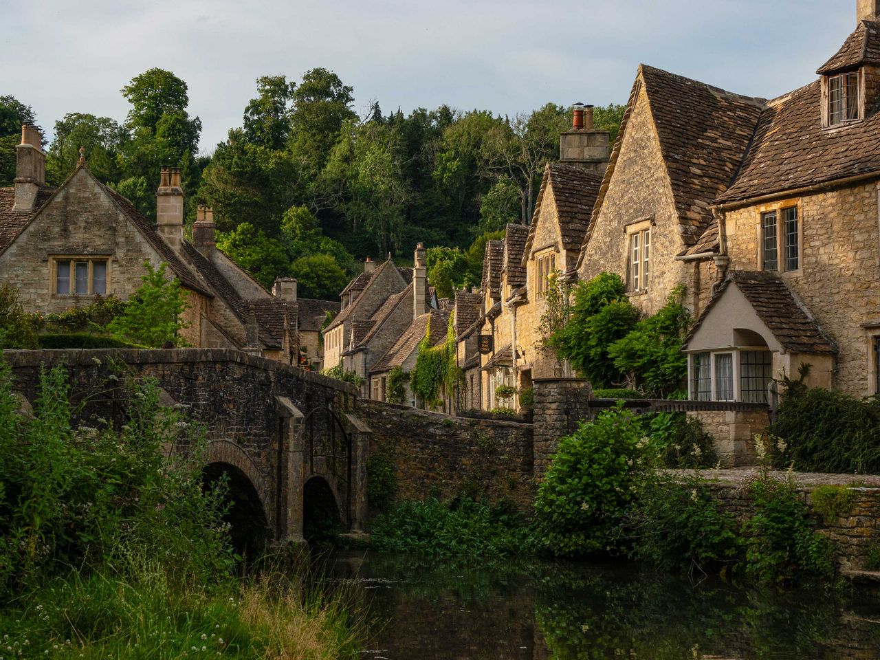 Blick auf H&auml;user und den Fluss Bybrook in Castle Combe, Cotswolds