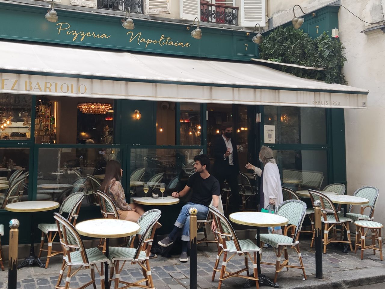 Tische und Personen im Außenbereich des Restaurants Chez Bartolo