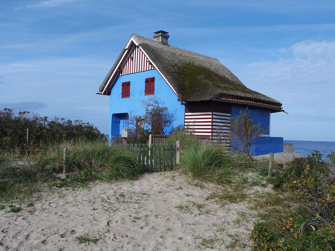 Blaues Haus mit Reetdach am Graswarder-Strand, Heiligenhafen (Ostsee)