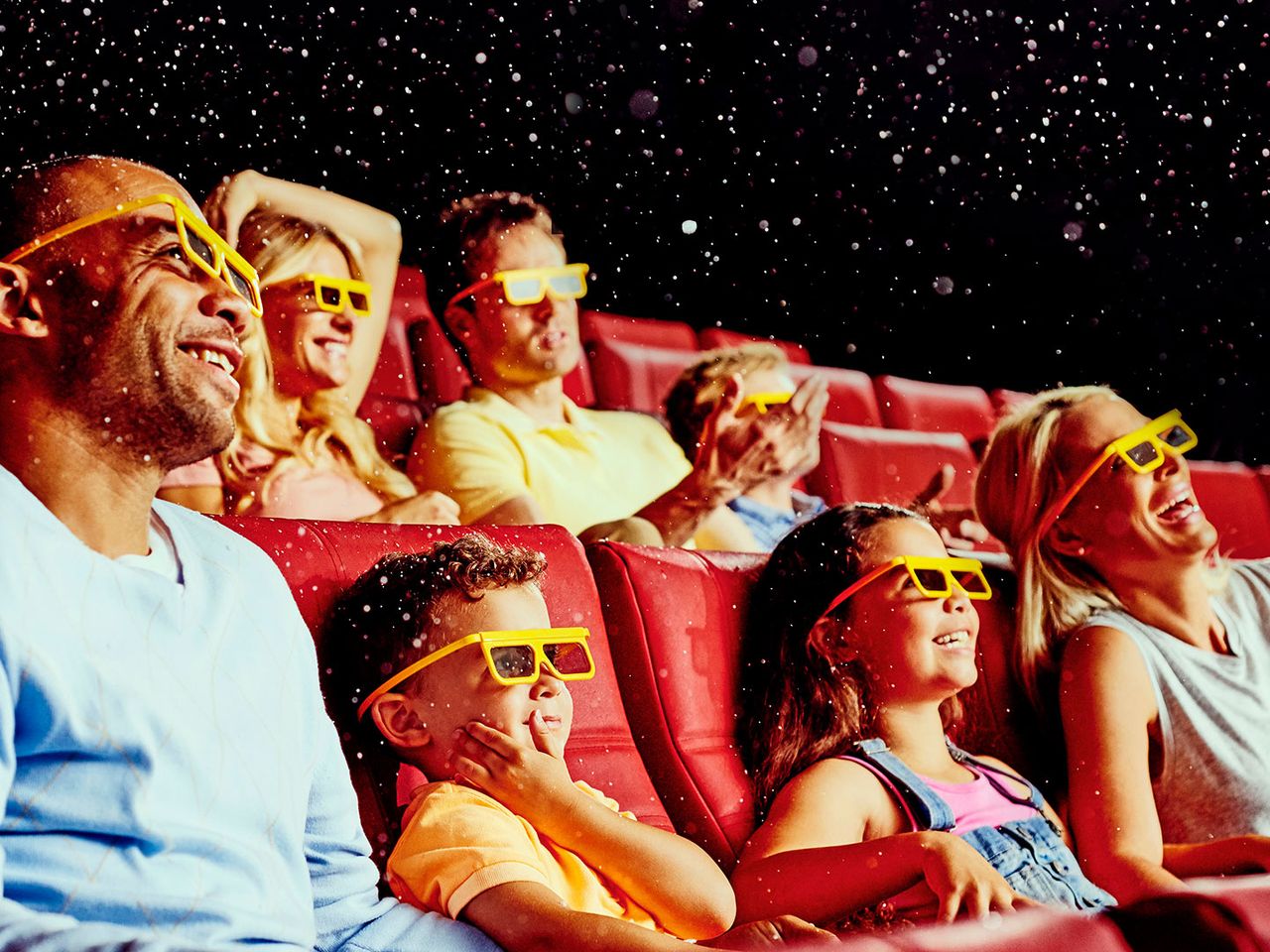 Besucher:innen schauen in einem Lego-4-D-Kino auf die Leinwand.