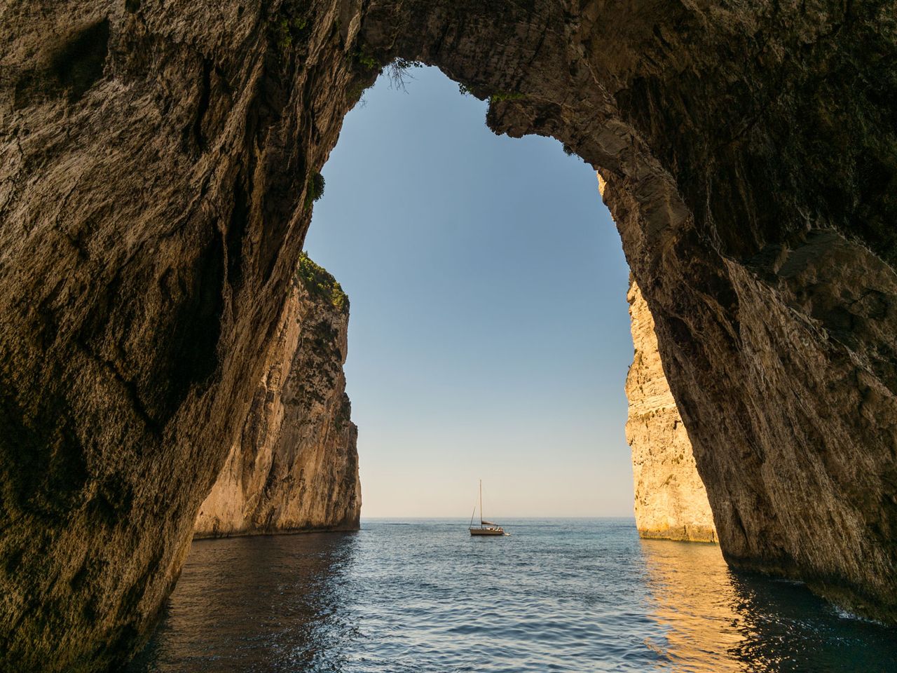 Blick aus einer Höhle auf ein Boot, Paxos