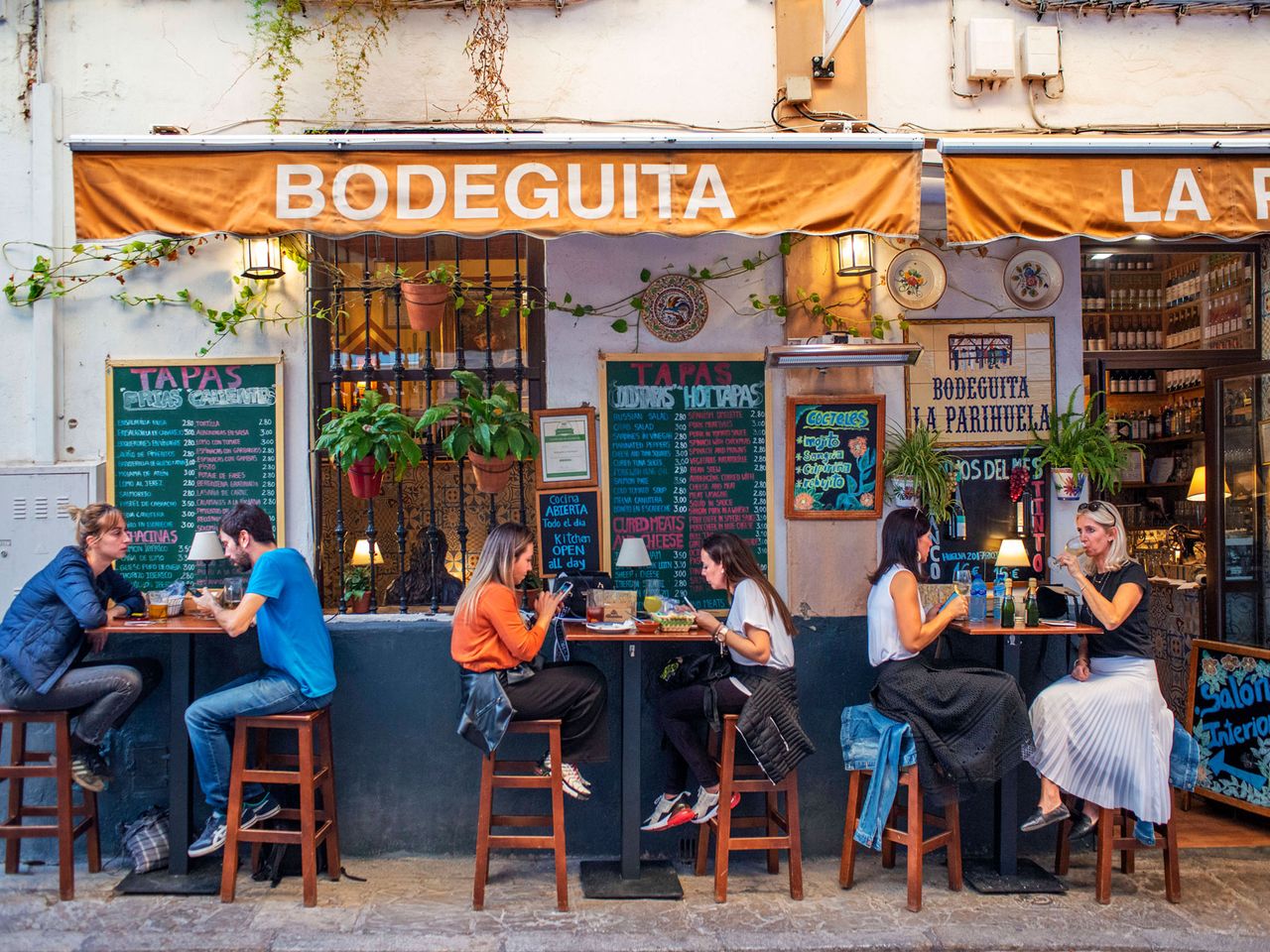 Menschen sitzen vor einer Tapasbar im Viertel Santa Cruz, Sevilla