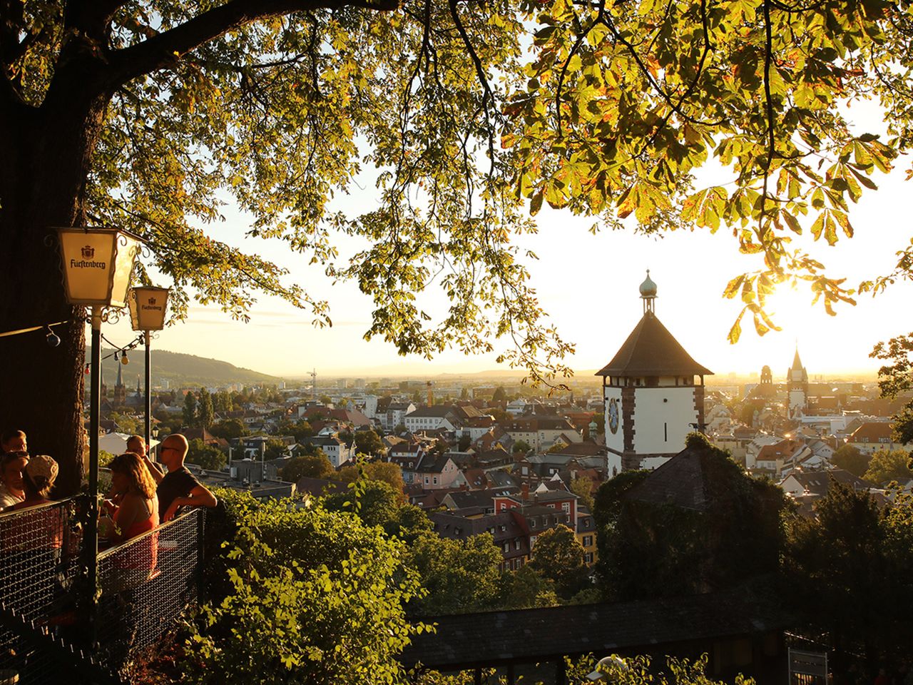 Blick auf die Dächer Freiburgs aus einem Biergarten.