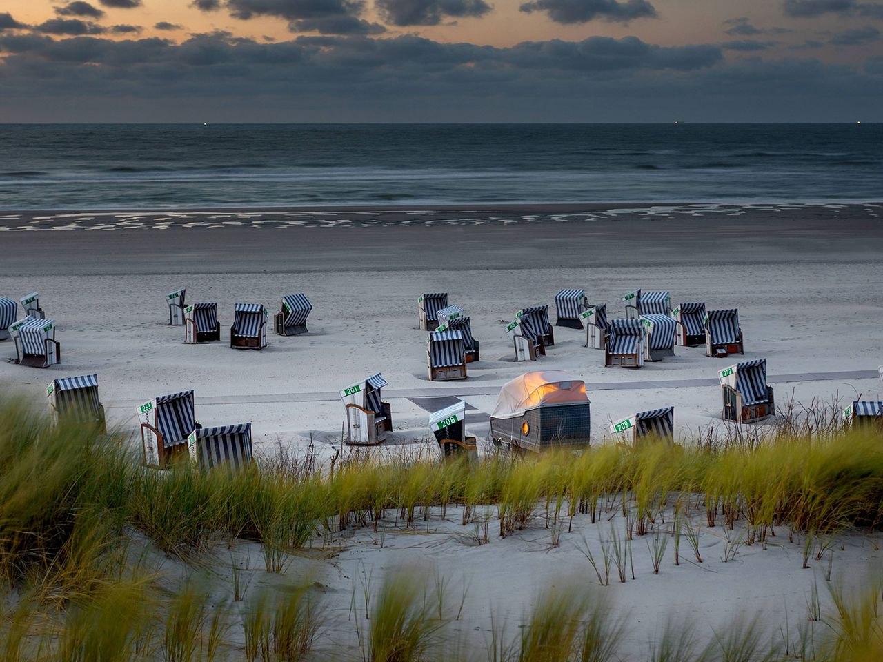 Strandkörbe und ein beleuchteter Schlafstrandkorb auf Norderney, am Strand