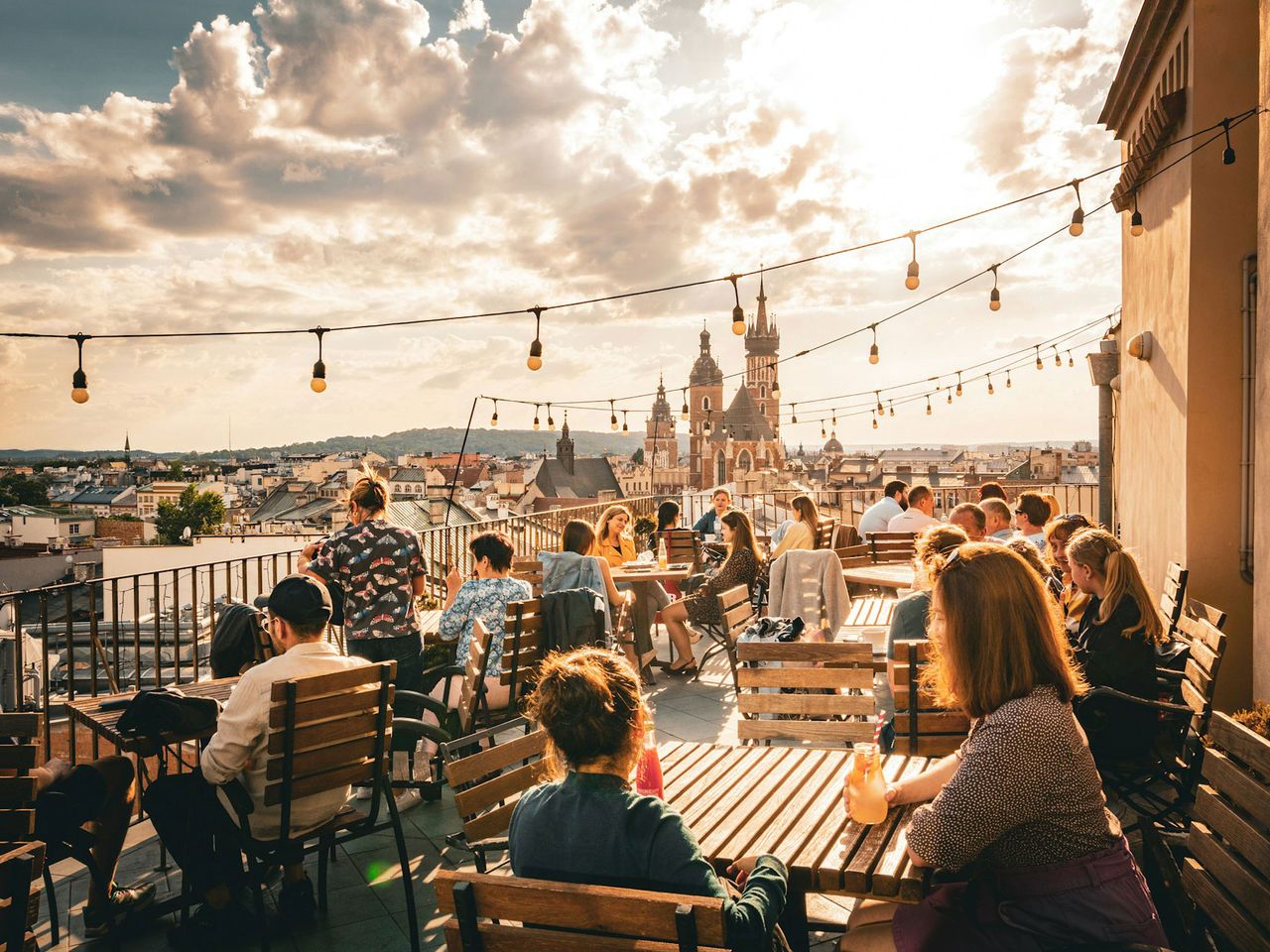 Menschen sitzen in Krakau auf einer Dachterrasse, Polen