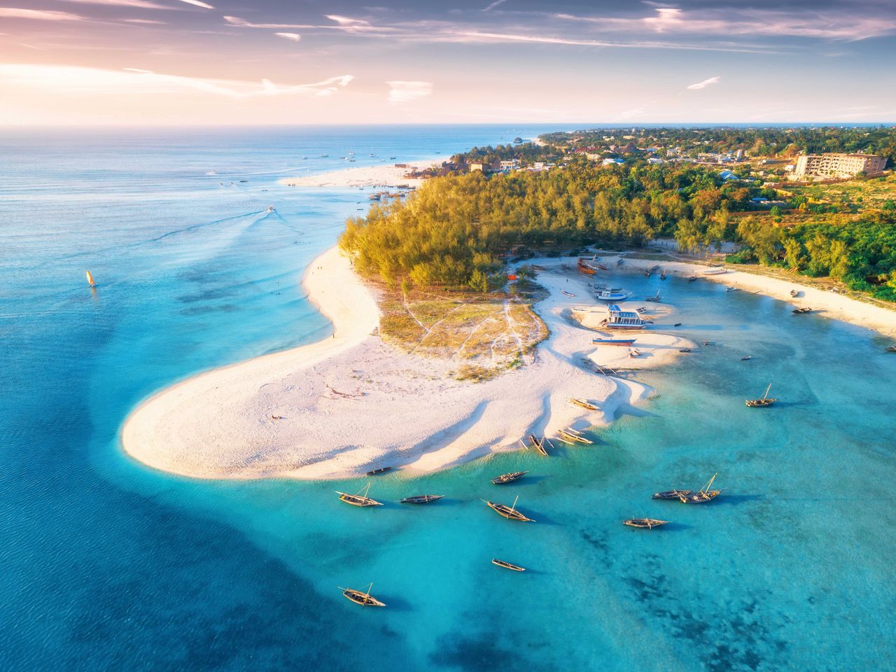 Blick auf einen Strand auf Sansibar, Boote schaukeln im Meer