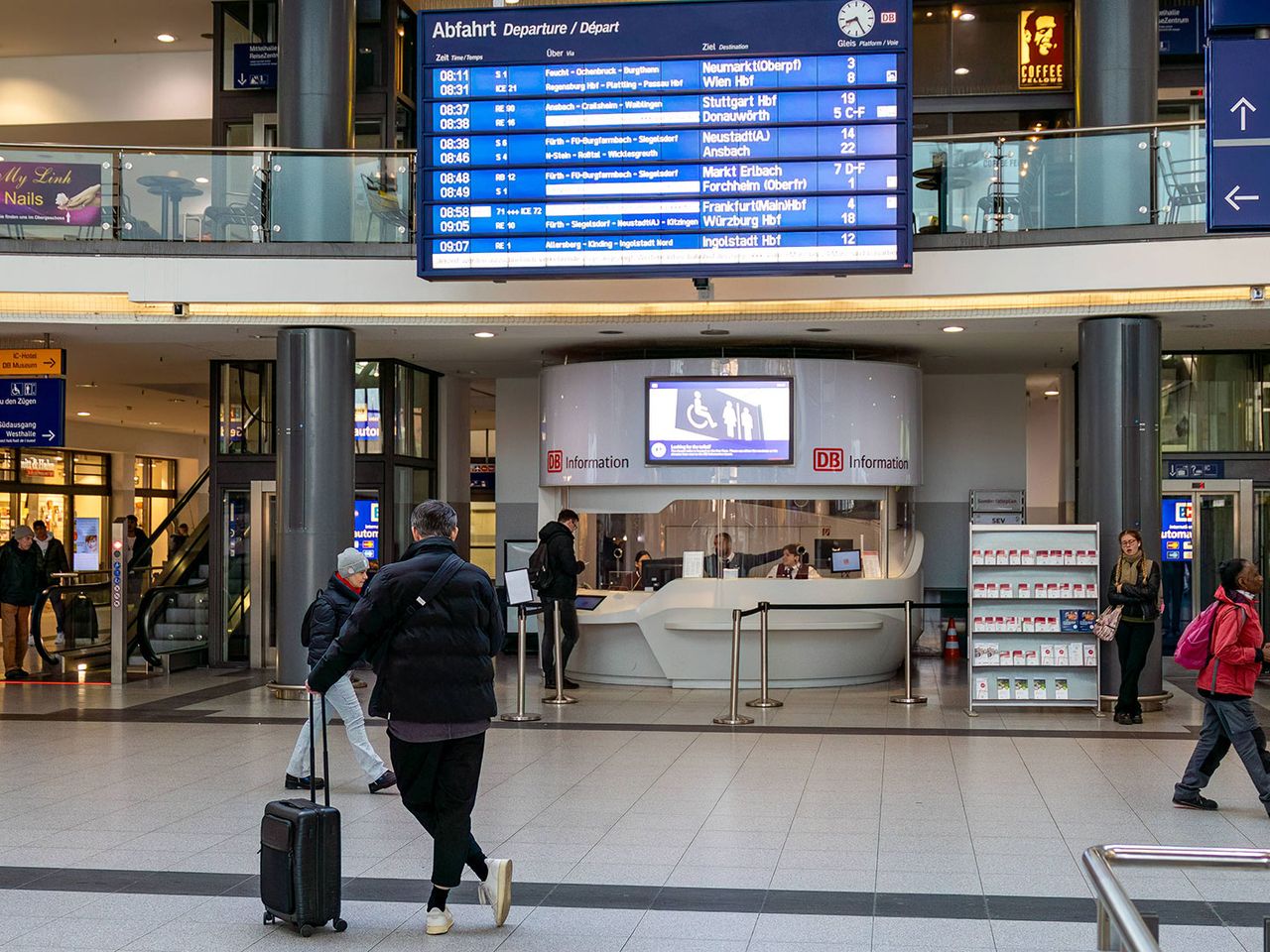 wenige Menschen am Nürnberger Hauptbahnhof, Anzeigetafel mit Ankündigungen