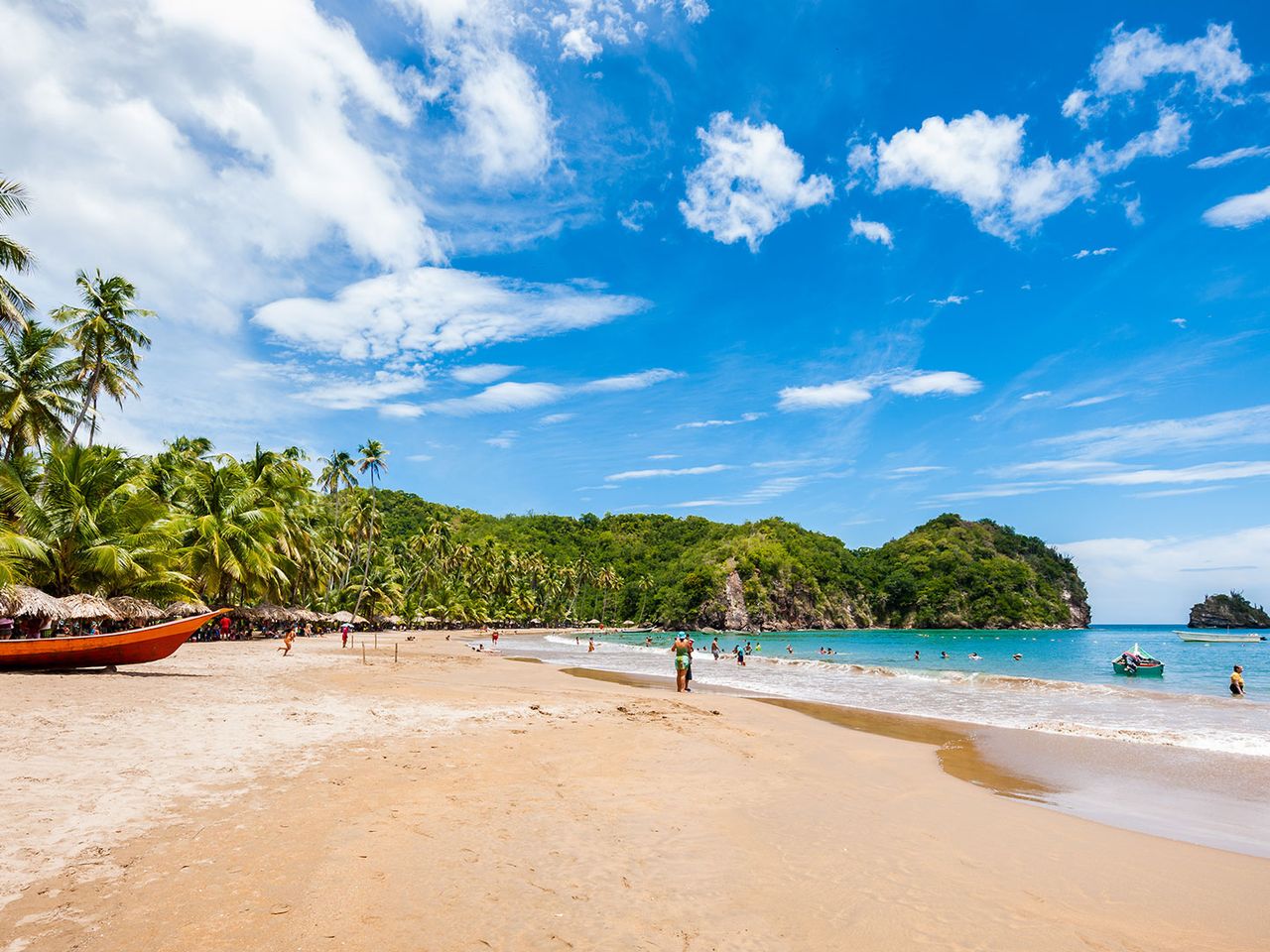 Blick auf die Playa Medina mit Menschen und Fischerboot, Venezuela