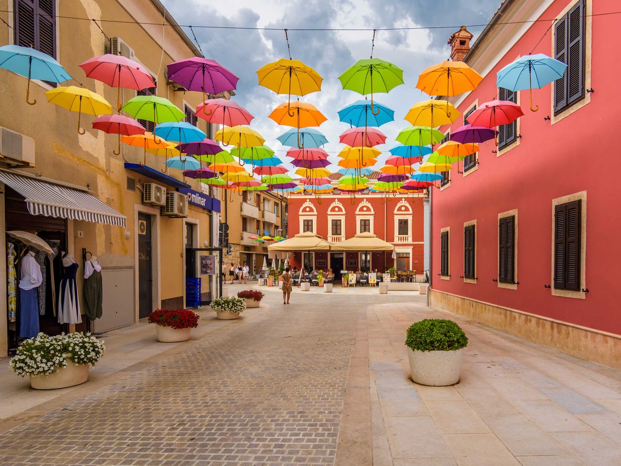 bunte Schirme in einer Gasse in Novigrad, Istrien (Kroatien)