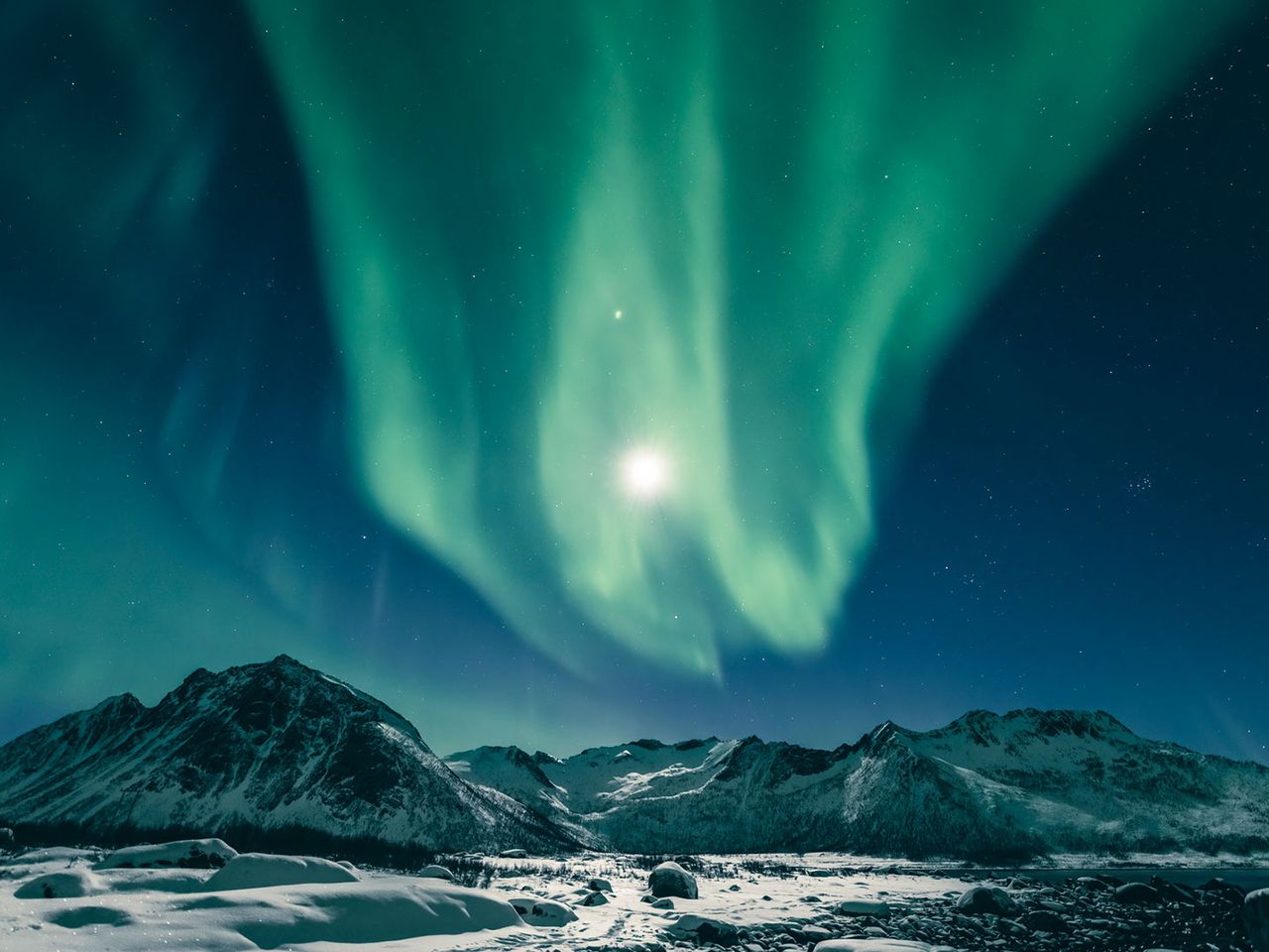 Polarlichter in Norwegen, über schneebedeckter Kulisse