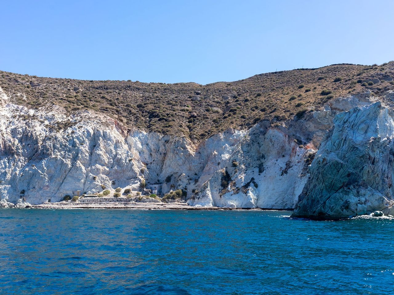 weiße Felswand ragt über das Meer, White Beach Santorini