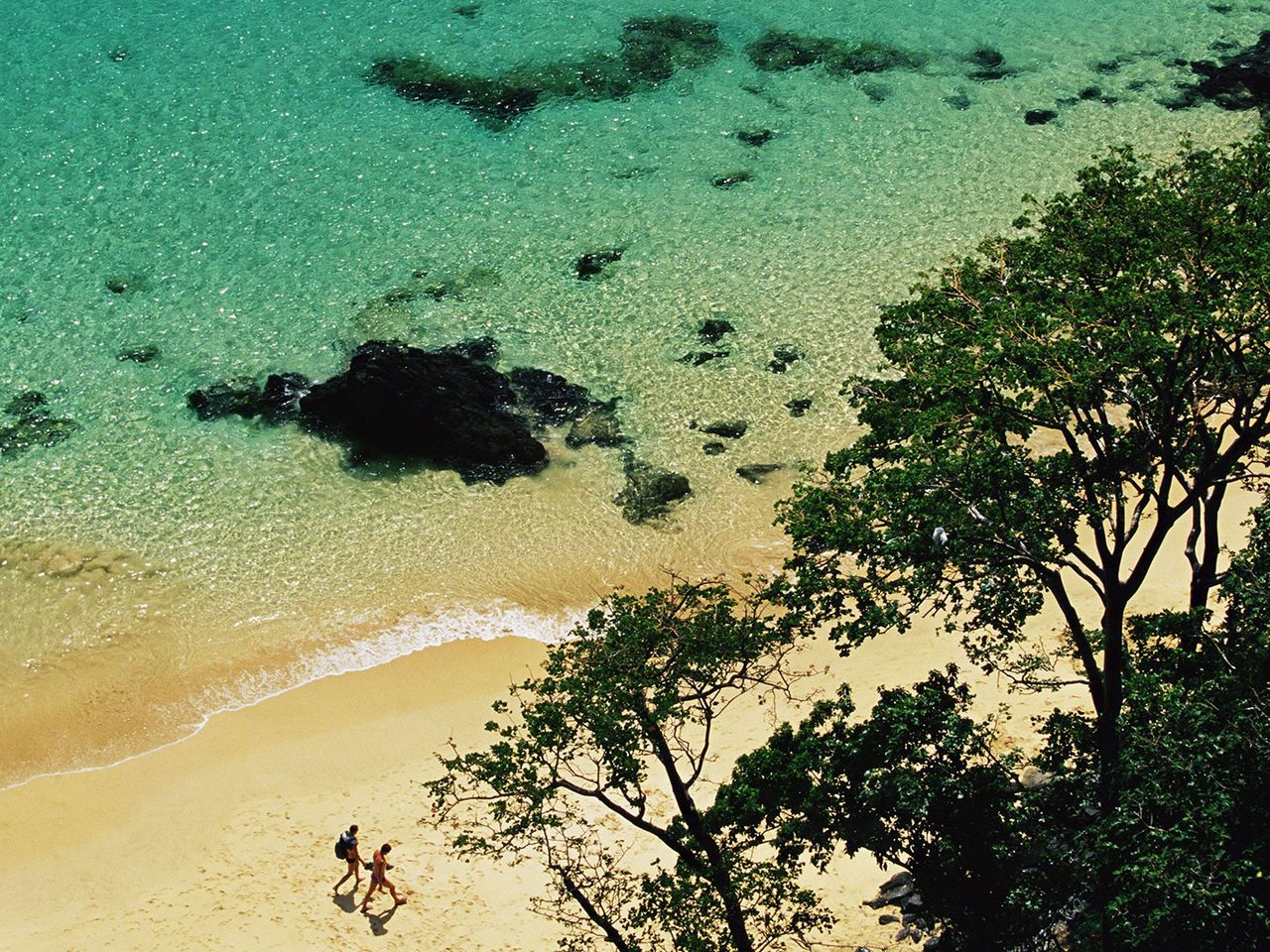 Zwei Personen gehen am Strand der Bucht Baia do Sancho in Brasilien entlang