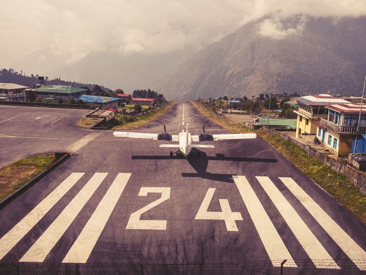 Ein kleines Flugzeug hebt von der kurzen Landebahn von Lukla mitten im Himalaja ab