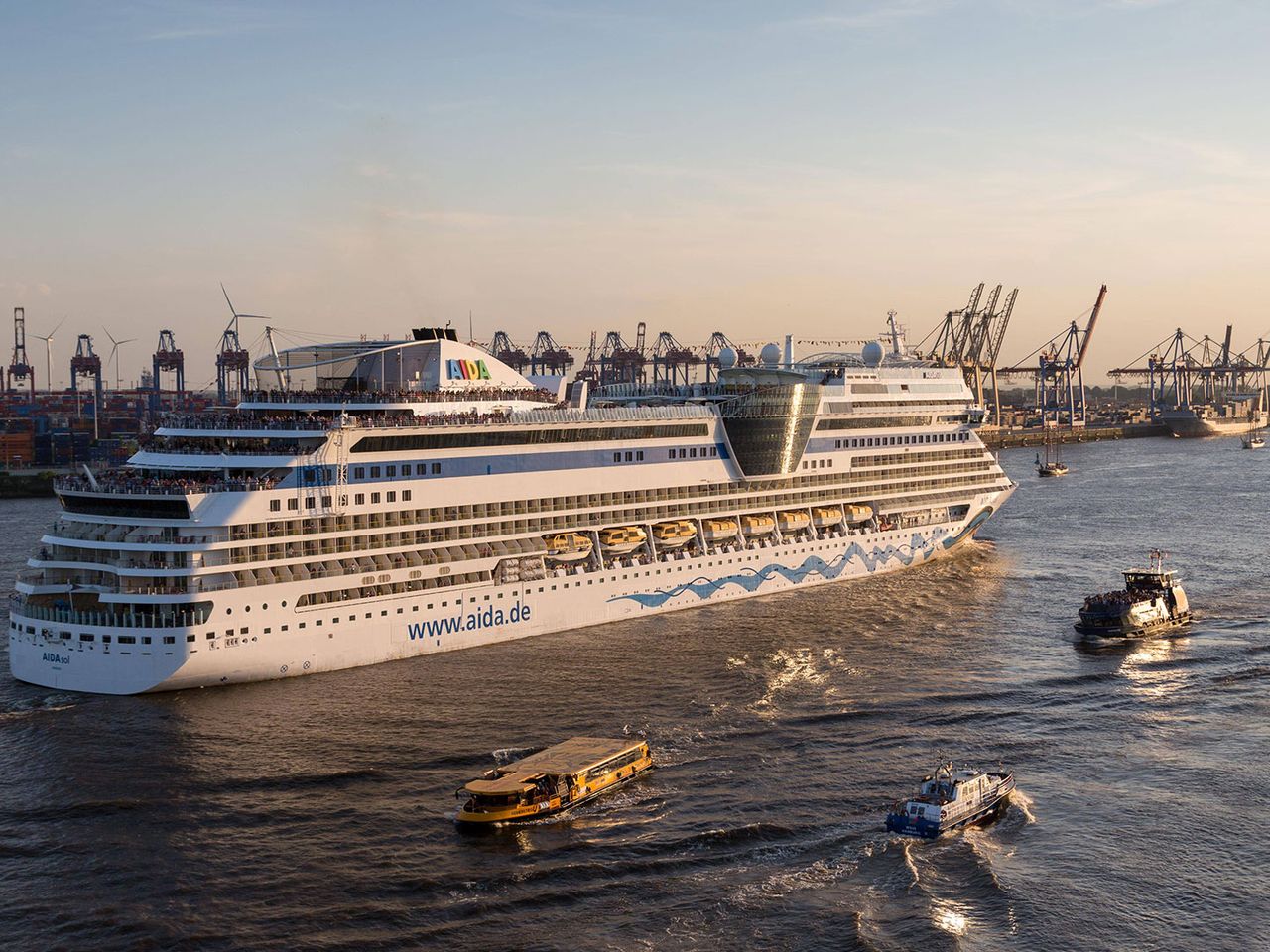 AIDAsol auf der Elbe, im Hintergrund die Kräne des Hamburger Hafens
