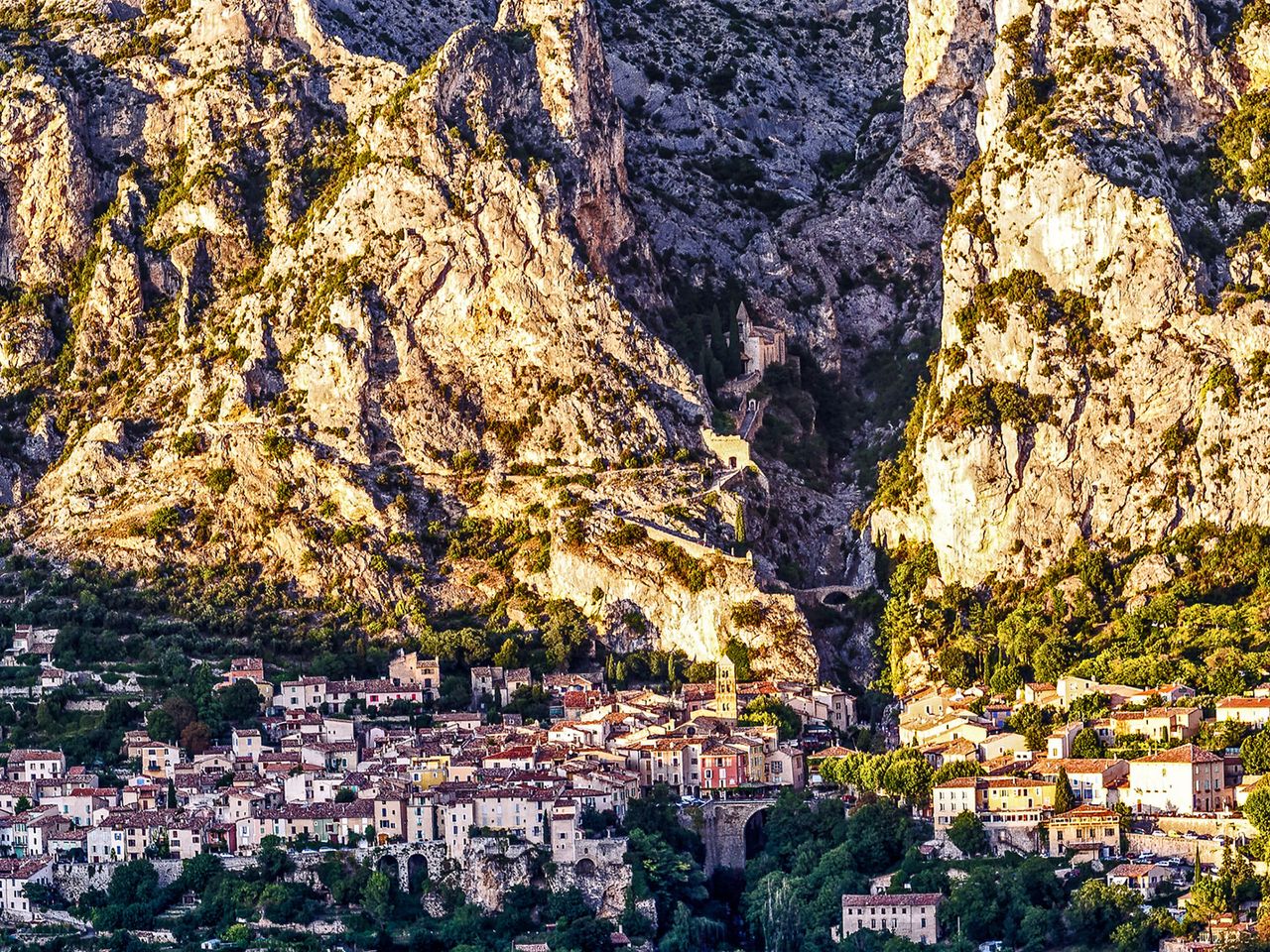 Hinter dem Dorf Moustiers-Sainte-Marie ragen die Berge auf