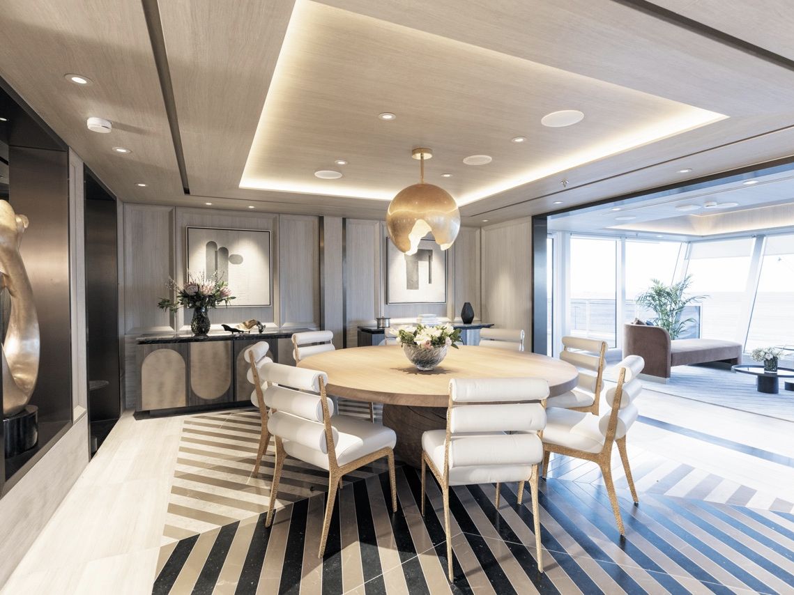 Ein heller, gro&szlig;z&uuml;giger Ess- und Wohnbereich einer luxuri&ouml;sen Suite auf einem Kreuzfahrtschiff.