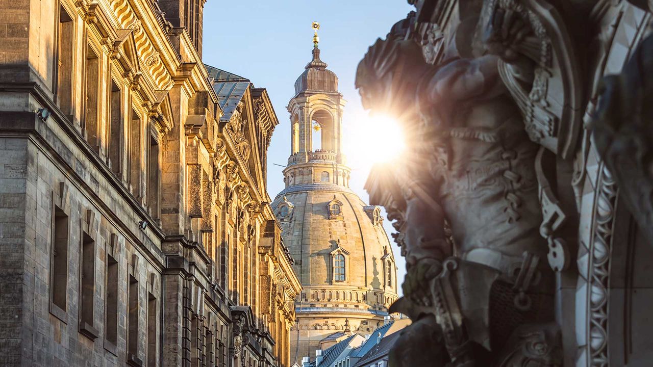 Blick zwischen historischen Gebäuden auf die Frauenkirche in Dresden