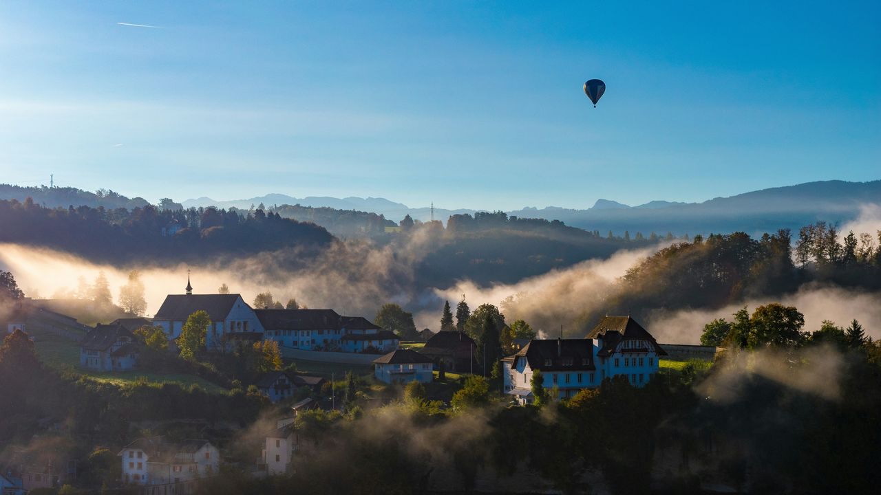 Hei&szlig;luftballon &uuml;ber Fribourg in der Schweiz