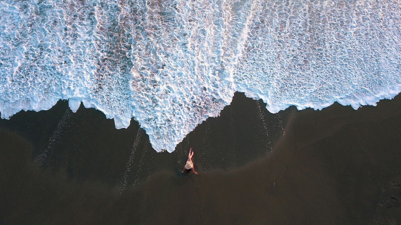 Luftaufnahme einer Frau am Lavastrand in Costa Rica