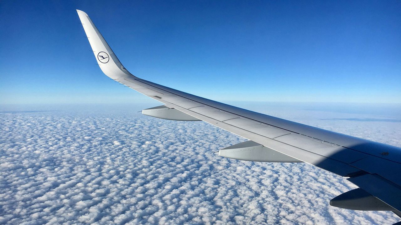 Tragfläche eines Lufthansa-Flugzeugs über den Wolken
