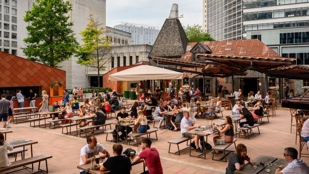 Menschen sitzen draußen im Viertel Spinningfields, Manchester