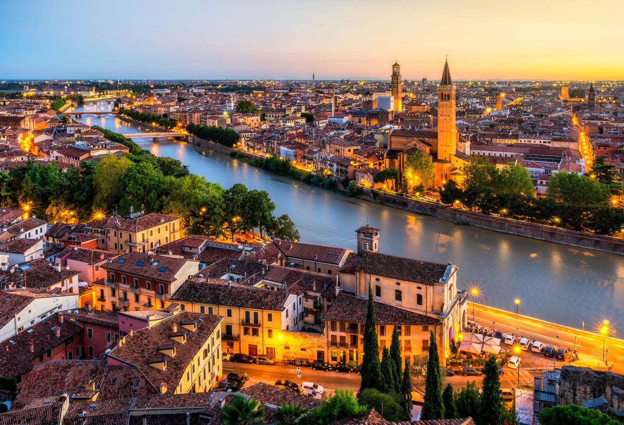 Blick auf die Etsch und Verona von oben, am Abend, beleuchtet
