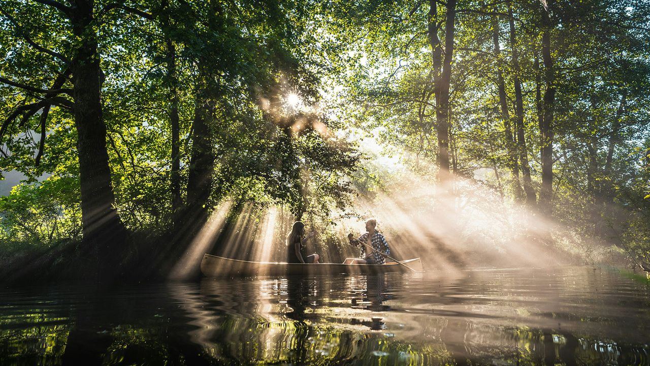 Zwei Personen paddeln in einem Boot auf einem See in Slowenien