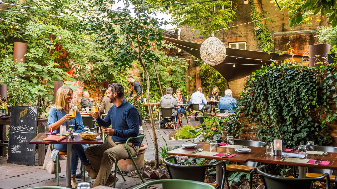 Personen sitzen im Garten des Miera Restaurants in Lübeck