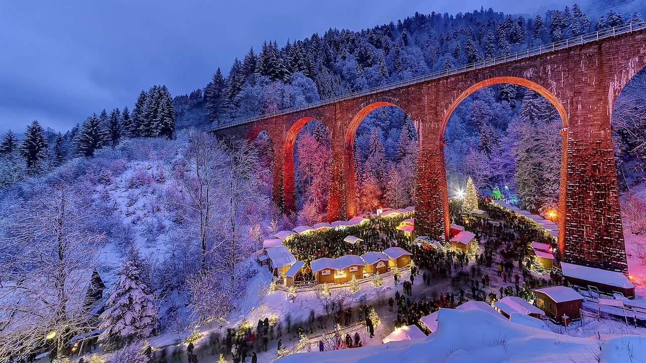 Blick auf die verschneite Ravennaschlucht mit Eisenbahnbrücke und Weihnachtsmarkt