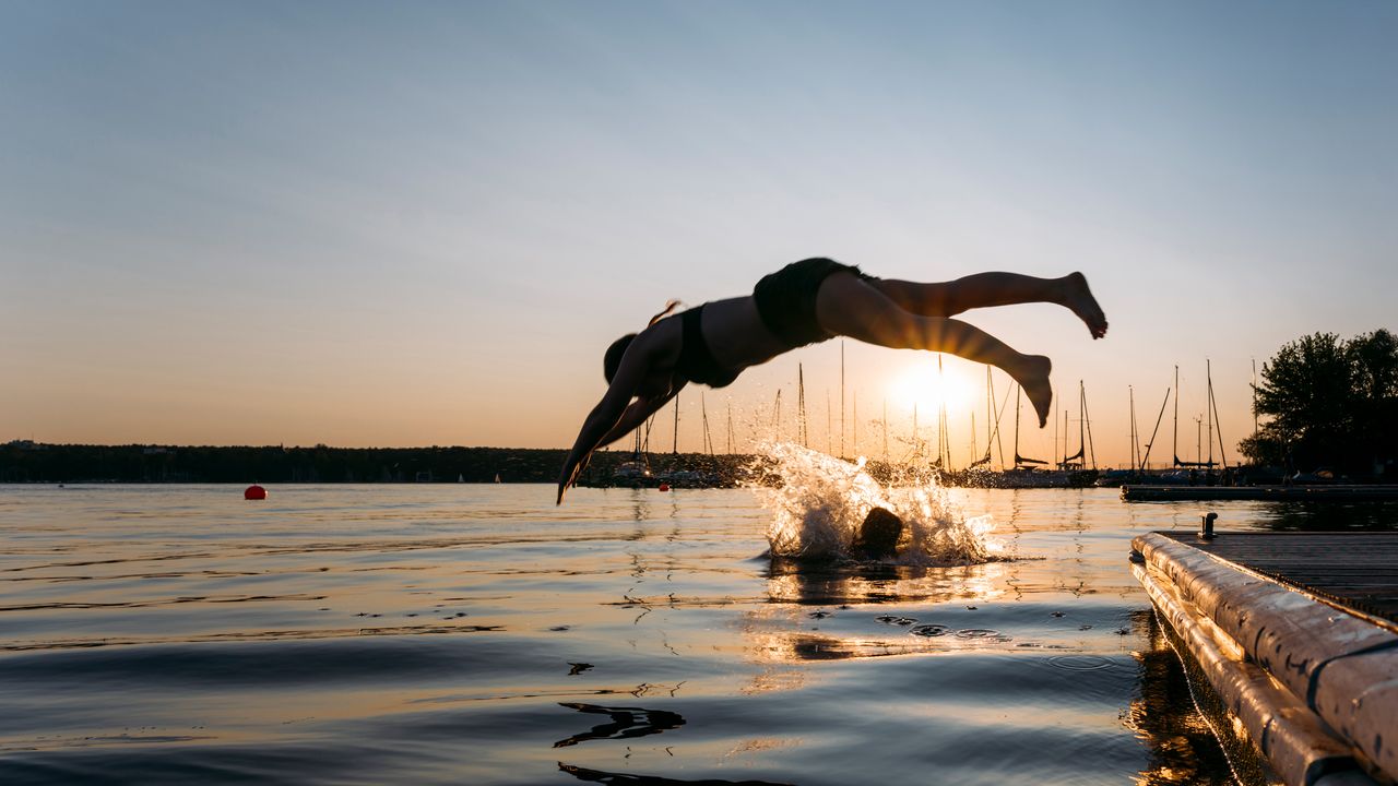 Frau springt bei Sonnenuntergang in den Berliner Wannsee