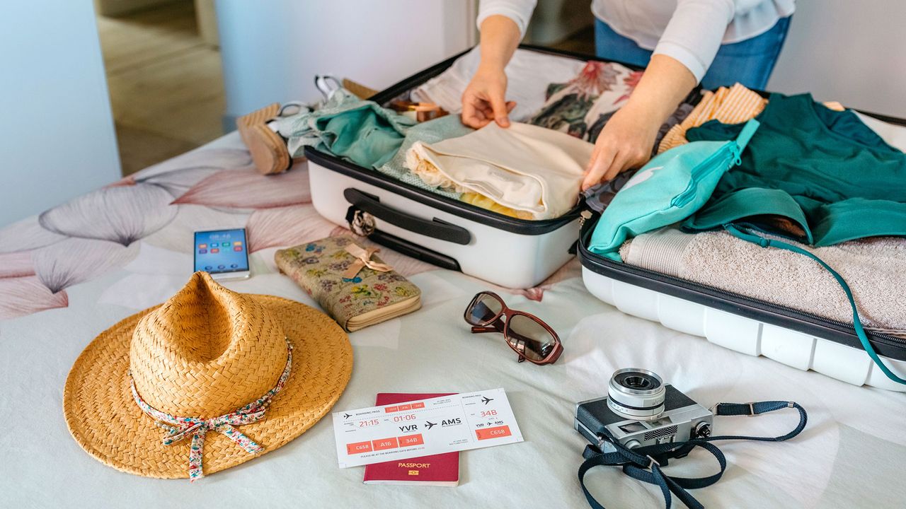 Eine Frau packt einen Koffer für eine Reise