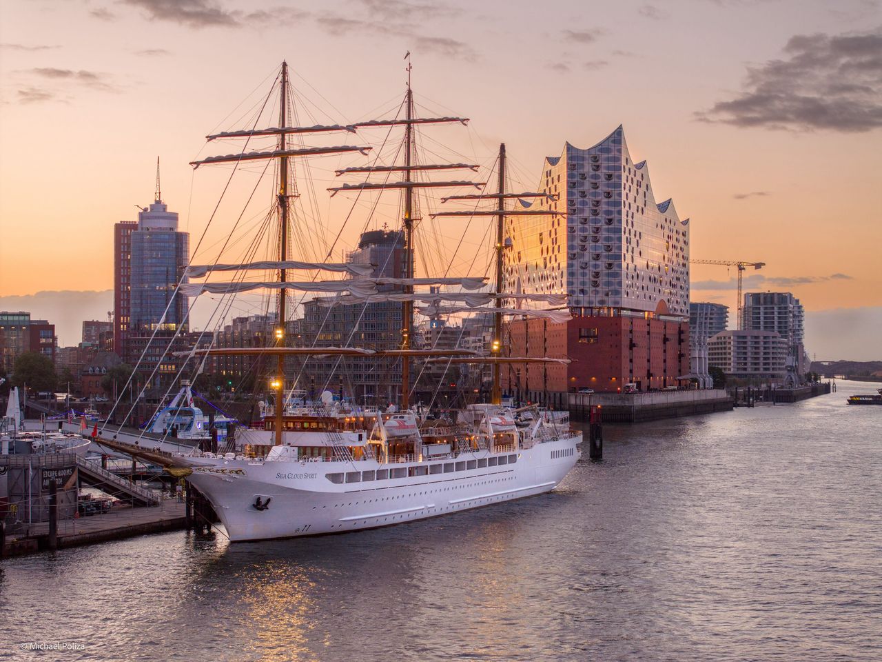 Ein großes Segelschiff liegt im Hamburger Hafen, dahinter die Elbphilharmonie